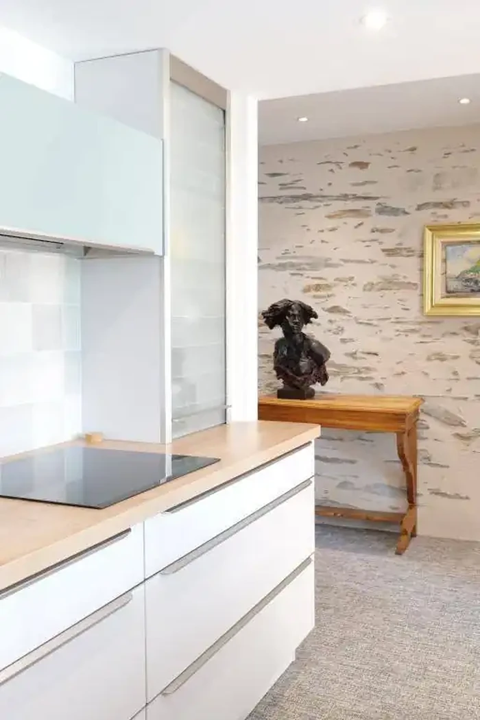 En cuisine, vue latérale sur le dégagement traité à pierres vues.